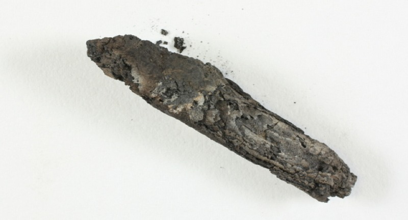 This lump of charcoal is actually one of the oldest known fragments of a biblical text, second only to the Dead Sea Scrolls. (Image: Shay Halevi/Israel Antiquities Authority)